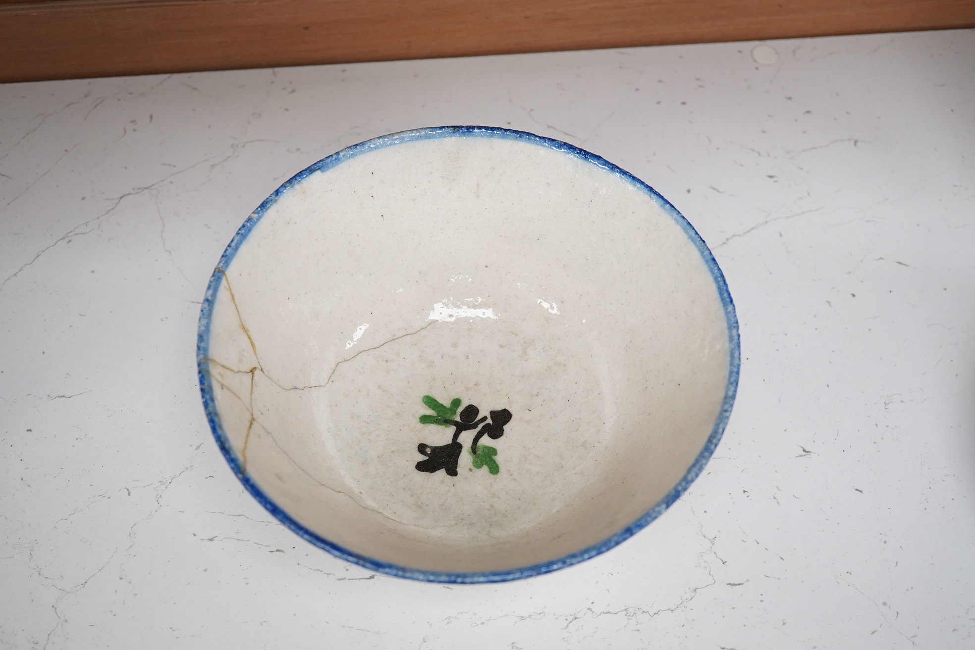 An 18th century Persian pottery bowl with bird decoration, 19cm diameter. Condition - poor